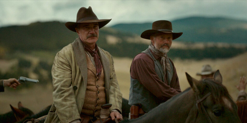 Tim DeKay and James Badge Dale in episode 2 of 1923. Both are wearing 20s era western style clothing and are on horseback.